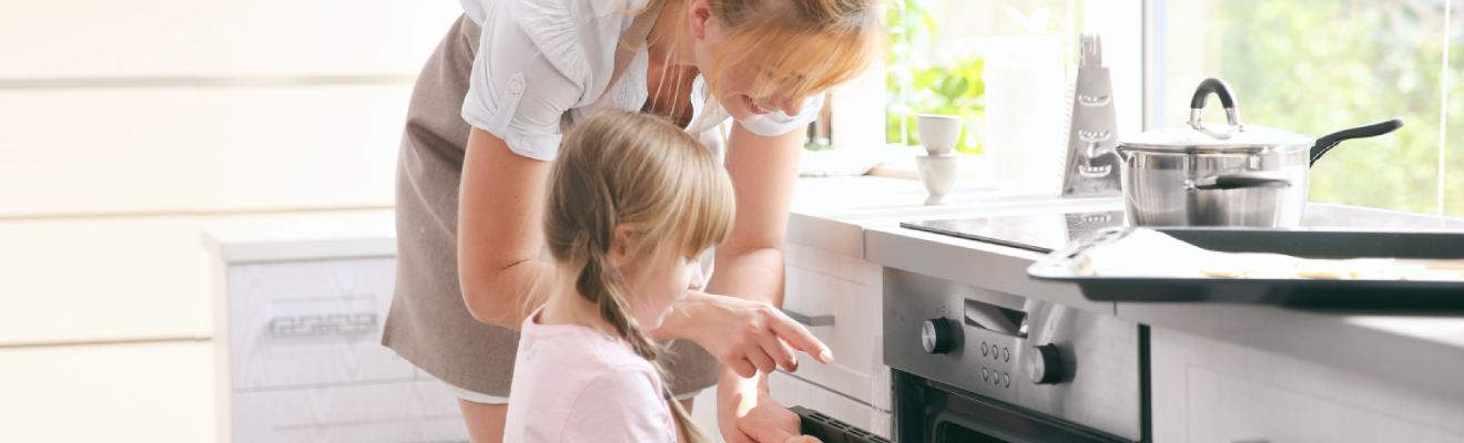 Lorem ipsum Eine Mutter klärt ihrer Tochter etwas vor einem Backofen